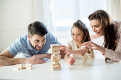 Happy family playing jenga game at home