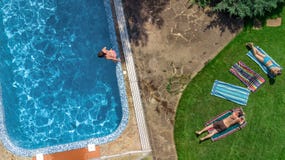 Happy family relaxing by swimming pool, aerial drone view from above of parents and kids have fun on vacation, family weekend stock photography Happy family relaxing by swimming pool, aerial drone view from above of parents and kids have fun on vacation, family weekend stock photography