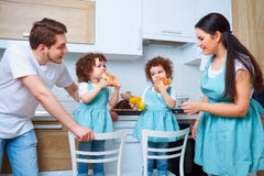 Happy family with twin daughters in the kitchen. Cheerful mother royalty free stock photos Happy family with twin daughters in the kitchen. Cheerful mother royalty free stock photos