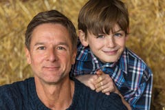 Happy Father Son Man and Boy Smiling on Hay Bales royalty free stock photography Happy Father Son Man and Boy Smiling on Hay Bales royalty free stock photography