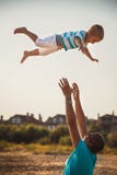 Happy father and son playing together at beach. Father throwing his son in the air stock photography Happy father and son playing together at beach. Father throwing his son in the air stock photography