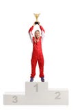 Happy female racer celebrating win on a winner`s pedestal with a Royalty Free Stock Photography Happy female racer celebrating win on a winner`s pedestal with a Royalty Free Stock Photography