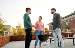 Happy friends having bbq party on rooftop stock image Happy friends having bbq party on rooftop stock image