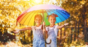 Happy funny sisters twins child girl with umbrella in autumn