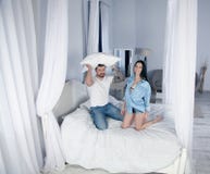 Happy girl and boy play pillows on the bed. it`s a real love royalty free stock image Happy girl and boy play pillows on the bed. it`s a real love royalty free stock image