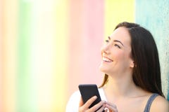 Happy girl holding phone thinking looking at side royalty free stock photography Happy girl holding phone thinking looking at side royalty free stock photography