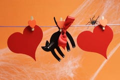Happy Halloween blank message for your text here on red hearts and black cat with pegs hanging from a line Stock Photo Happy Halloween blank message for your text here on red hearts and black cat with pegs hanging from a line Stock Photo