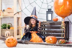 Happy Halloween. A little beautiful girl in a witch costume celebrates a home in an interior royalty free stock photos Happy Halloween. A little beautiful girl in a witch costume celebrates a home in an interior royalty free stock photos