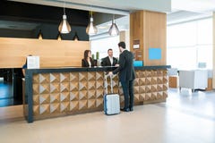 Happy Hotel Clerks Are Welcoming Professional At Counter Stock