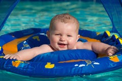 Happy infant playing in pool while sitting in baby float stock images Happy infant playing in pool while sitting in baby float stock images