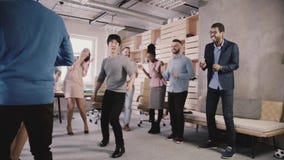 Happy Japanese employee doing funny dance moves at casual office celebration party. Team celebrates success slow motion. stock video Happy Japanese employee doing funny dance moves at casual office celebration party. Team celebrates success slow motion. stock video