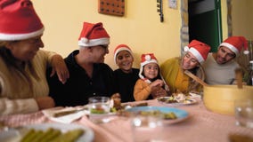 Happy Latin family dining while celebrating Christmas holidays at home