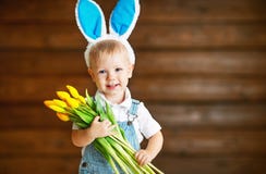 Happy laughing baby boy in bunny ears with yellow tulips on wo royalty free stock images Happy laughing baby boy in bunny ears with yellow tulips on wo royalty free stock images