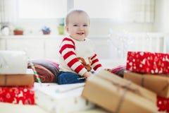Happy little baby girl opening Christmas presents on her very first Christmas royalty free stock photography Happy little baby girl opening Christmas presents on her very first Christmas royalty free stock photography
