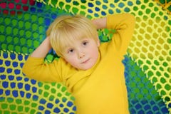 Happy little boy having fun in amusement in play center. Child playing on indoor playground royalty free stock images Happy little boy having fun in amusement in play center. Child playing on indoor playground royalty free stock images