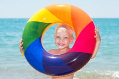 Happy little boy playing with colorful inflatable ring on hot summer day. Child water toys. Children play in tropical resort. Fami royalty free stock photography Happy little boy playing with colorful inflatable ring on hot summer day. Child water toys. Children play in tropical resort. Fami royalty free stock photography