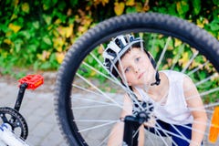 Happy little child boy in white helmet repairing his bicycle stock photo Happy little child boy in white helmet repairing his bicycle stock photo