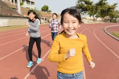 Happy little girls running on the track stock photo Happy little girls running on the track stock photo