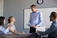 Happy male boss praising employees appreciating good work result stock photo Happy male boss praising employees appreciating good work result stock photo