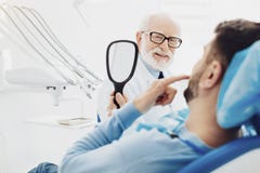 Happy male patient examining his teeth stock image Happy male patient examining his teeth stock image