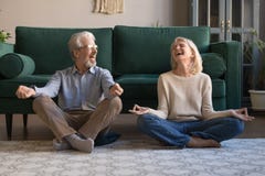 Happy mature couple having fun, practicing yoga together at home royalty free stock image Happy mature couple having fun, practicing yoga together at home royalty free stock image