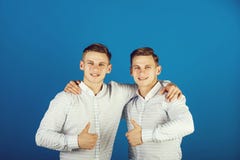 Happy men hugging and showing thumbs up gestures stock photo Happy men hugging and showing thumbs up gestures stock photo