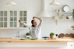 Happy millennial woman have fun cooking breakfast in kitchen