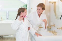 Happy mother and daughter brushing teeth together royalty free stock photos Happy mother and daughter brushing teeth together royalty free stock photos