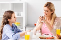 Happy mother and daughter having breakfast at home royalty free stock photos Happy mother and daughter having breakfast at home royalty free stock photos