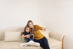 Happy mother and doughter relaxing and playing TV games on the s royalty free stock photography Happy mother and doughter relaxing and playing TV games on the s royalty free stock photography
