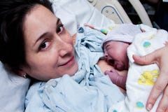 Happy mother holding newborn baby after birth