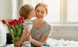 Happy mother`s day! child son gives flowers for  mother on holiday