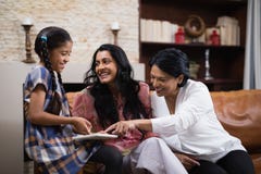 Happy multi-generation family using digital tablet together at home Stock Image Happy multi-generation family using digital tablet together at home Stock Image