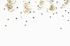 Happy New Year or birthday festive composition. Golden confetti and glittering stars on white table background