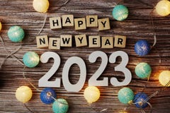 Happy New Year 2023 decorate with LED cotton ball on wooden background. Top View of Happy New Year 2023 decorate with LED cotton ball on wooden background