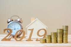 2019 Happy New Year with gold coins stack and wooden number on table. business, investment, retirement planning, finance, Saving a stock photo 2019 Happy New Year with gold coins stack and wooden number on table. business, investment, retirement planning, finance, Saving a stock photo