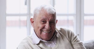 Happy older man with healthy white teeth looking at camera.