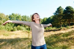 Happy older woman standing outside with arms outstretched royalty free stock photo Happy older woman standing outside with arms outstretched royalty free stock photo