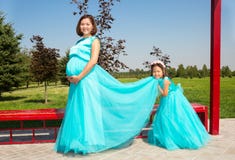 Happy pregnant asian mom and child girl hugging. The concept of childhood and family. Beautiful Mother and her baby outdoor stock images Happy pregnant asian mom and child girl hugging. The concept of childhood and family. Beautiful Mother and her baby outdoor stock images