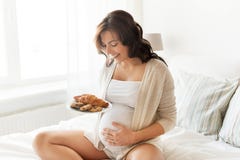 Happy pregnant woman with croissant buns at home royalty free stock images Happy pregnant woman with croissant buns at home royalty free stock images