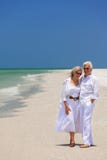 Happy Senior Couple Laughing Embracing on a Tropical Beach stock images Happy Senior Couple Laughing Embracing on a Tropical Beach stock images