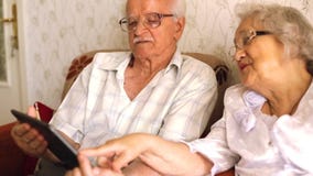 Happy senior couple using modern tablete