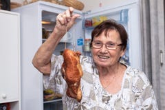Happy senior woman holding smoked meat Stock Images Happy senior woman holding smoked meat Stock Images