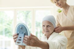 Sick elderly woman with headscarf and caregiver looking in the mirror stock photos Sick elderly woman with headscarf and caregiver looking in the mirror stock photos