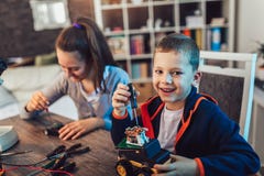Smiling boy and girl constructs technical toy and make robot. Technical toy on table full of details royalty free stock photos Smiling boy and girl constructs technical toy and make robot. Technical toy on table full of details royalty free stock photos