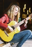 Happy Smiling Caucasian Blond Girl Playing The Guitar Outside On Street. Combination Of Flash And Halogen Royalty Free Stock Photography