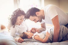 Awaking. Parents with daughter in bed. royalty free stock photography Awaking. Parents with daughter in bed. royalty free stock photography