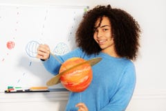 Happy smiling girl holding planet model of Saturn stock image Happy smiling girl holding planet model of Saturn stock image