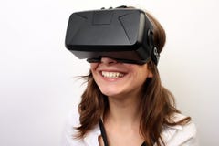 Happy, smiling woman in a white shirt, wearing Oculus Rift VR Virtual reality 3D headset, laughing