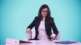 Happy smiling young brunette in a business suit shows thumb on the camera. She sits in the office behind a Desk. stock video footage Happy smiling young brunette in a business suit shows thumb on the camera. She sits in the office behind a Desk. stock video footage